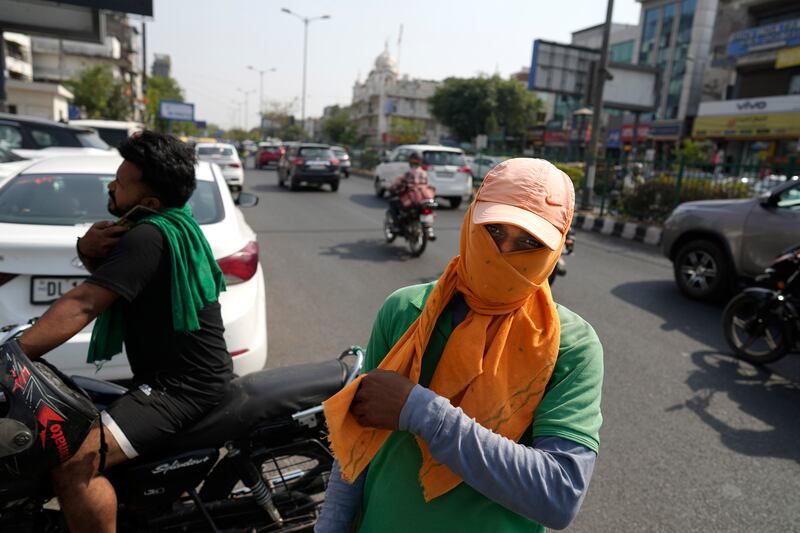 A parking attendant in New Delhi protects his face from the sun with a scarf. AP