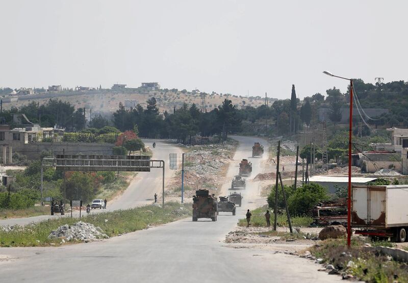 Military vehicles of a joint Russian-Turkish patrol pass through the M4 highway on the outskirts of the rebel-held town of Ariha in Syria's northwestern Idlib province on May 7, 2020.  / AFP / Omar HAJ KADOUR
