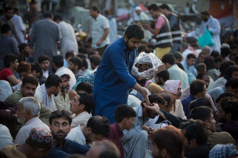 A Pakistani volunteers distributes dates in Rawalpindi. AP Photo