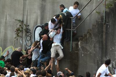 German police officers lift up a woman from the crowd of revellers outside a tunnel at the Love Parade in 2010. Reuters