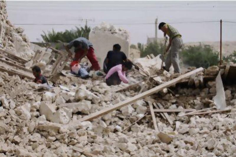 Iranians collect their belongings from the rubble of their home in the village of Darvisheh, southeast of Bushehr.