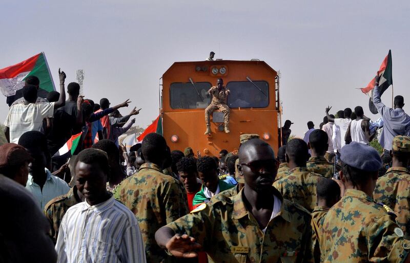 Sudanese military and demonstrators attending a sit-in block a train from passing through, during a protest outside the Defence Ministry in Khartoum. Reuters