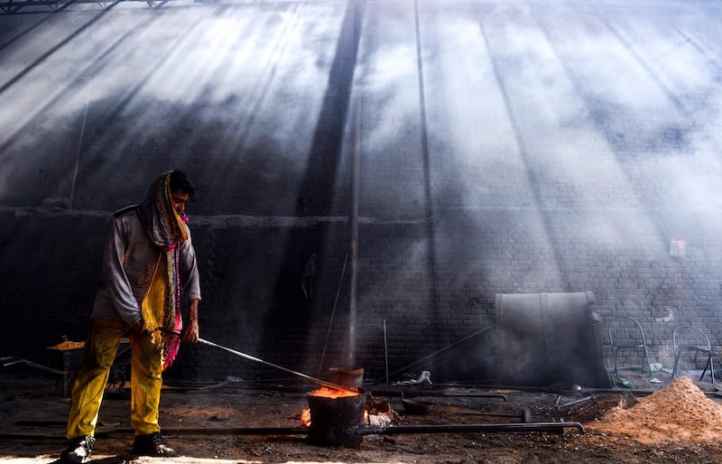 A Pakistani labourer works at an iron forge in Lahore.  AFP