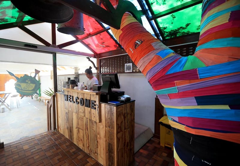 A frangipani tree around which the Art House Cafe in Abu Dhabi was built is decorated with material cut from discarded T-shirts. Ravindranath K / The National
