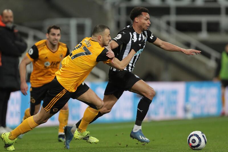 Newcastle's Jacob Murphy, right, is challenged by Wolverhampton Wanderers' Romain Saiss during the English Premier League soccer match between Newcastle United and Wolves at the St James' Park stadium in Newcastle, England, Sunday, Feb. 27, 2021. (Richard Sellars/Pool via AP)