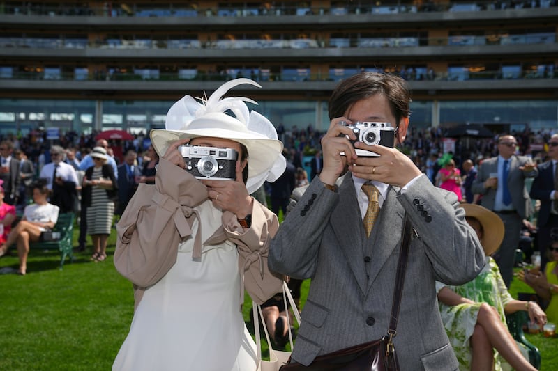 Two racegoers photograph the photographer on the second day of Britain's Royal Ascot horse race meeting. AP