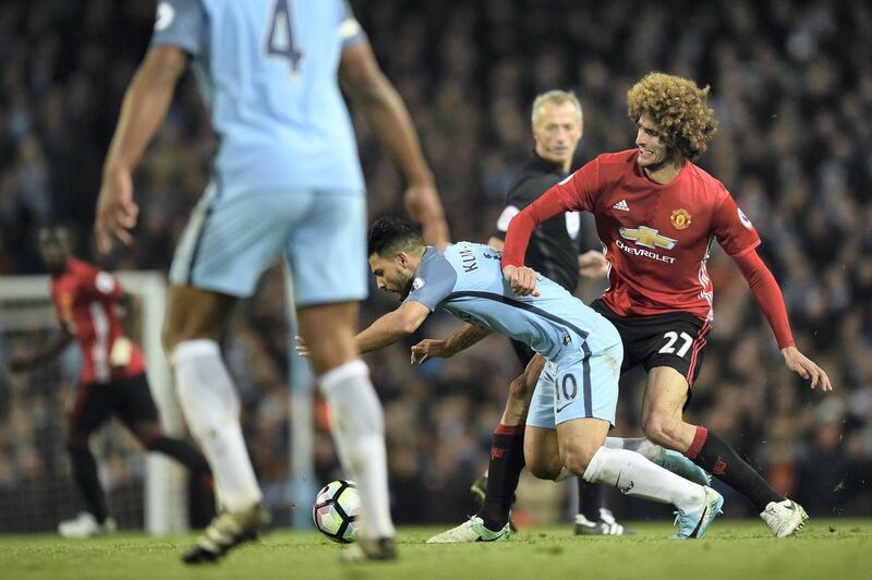 Manchester United's Belgian midfielder Marouane Fellaini (R) fouls Manchester City's Argentinian striker Sergio Aguero (2L) to earn a yellow card during the English Premier League football match between Manchester City and Manchester United at the Etihad Stadium in Manchester, north west England, on April 27, 2017. (Photo by Oli SCARFF / AFP) / RESTRICTED TO EDITORIAL USE. No use with unauthorized audio, video, data, fixture lists, club/league logos or 'live' services. Online in-match use limited to 75 images, no video emulation. No use in betting, games or single club/league/player publications. / 