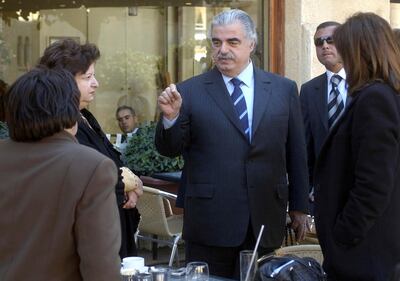 FILE - In this Feb. 14, 2005 file photo, former Lebanese Prime Minister Rafik Hariri, center, speaks to people outside the Lebanese Parliament minutes before an explosion killed him and 22 others, in Beirut, Lebanon. More than 15 years after the truck bomb assassination of Hariri in Beirut, a U.N.-backed tribunal in the Netherlands is announcing verdicts this week in the trial of four members of the militant group Hezbollah allegedly involved in the killing. (AP Photo, File)