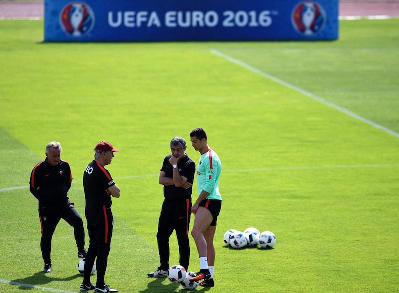 Portugal’s forward Cristiano Ronaldo (R) speaks with Portugal’s coach Fernando Santos (2nd R) and assistant coach Ilidio Vale (2nd L) during a  training session at the team’s training ground in Marcoussis, south of Paris, on July 8, 2016, ahead of their Euro 2016 final football match against France. / AFP / FRANCISCO LEONG