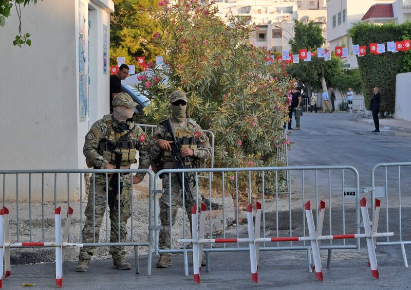Members of Tunisian security forces stand guard outside a polling station in Ariana district of Tunis. AFP
