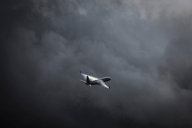 A Virgin Australia Airlines Boeing 737 plane flies as a storm approaches at Sydney International Airport. AFP