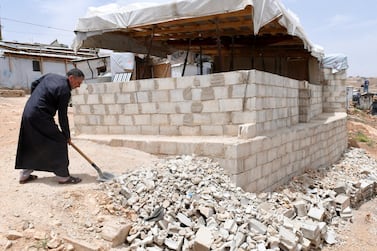 A Syrian refugee removes rubble as he dismantles his shelter to meet regulations at the Lebanese border town of Arsal, Lebanon. Reuters 