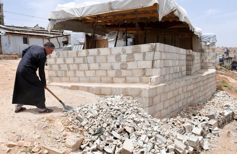 A Syrian refugee removes rubble as he dismantles his shelter at the Lebanese border town of Arsal, Lebanon June 9, 2019. Picture taken June 9, 2019. REUTERS/Hassan Abdallah