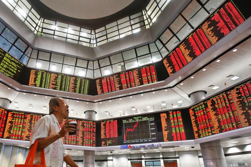 A man watches trading boards at a private stock market gallery in Kuala Lumpur, Malaysia, Friday, Feb. 9, 2018. Asian stocks plunged Friday after Dow Jones industrials on Wall Street plummeted more than 1,000 points, deepening a week-long sell-off. (AP Photo/Sadiq Asyraf)
