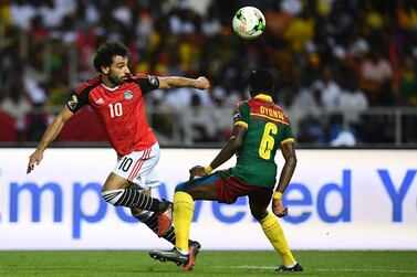 Egypt forward Mohamed Salah, left, vies for the ball against Cameroon defender Ambroise Oyongo. Gabriel Bouys / AFP