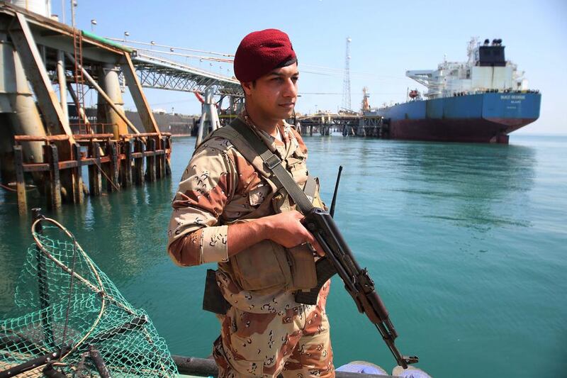 An Iraqi navy stands guard while an oil tanker loads crude oil at the Al Basra offshore terminal. Nabil Al Jurani / AP Photo