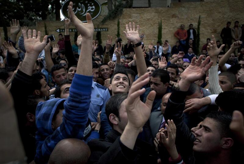 Palestinian singer and the last season's Arab Idol winner Mohammed Assaf, centre, joins hundreds of Palestinian youths cheering, while waiting for a chance to compete in the Arab world's premier talent show Arab Idol, at the luxury Grand Park Hotel, in the West Bank city of Ramallah on Monday, March 17, 2014. AP 