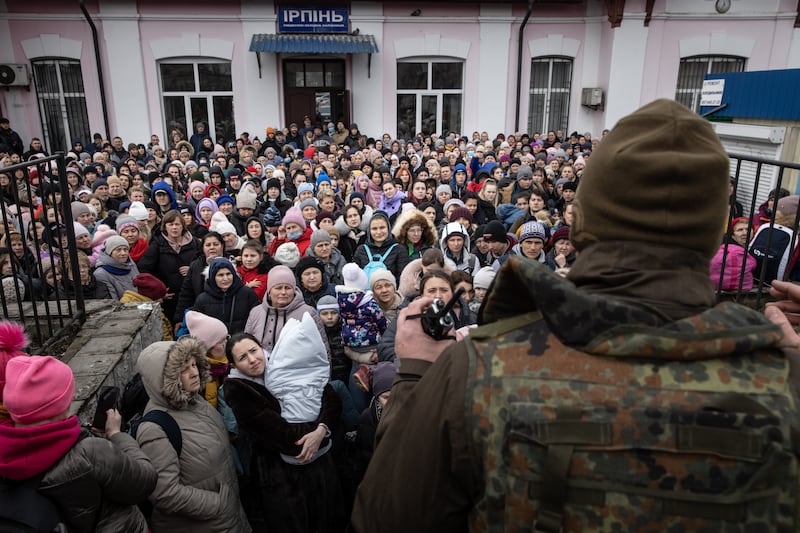 A member of the Ukrainian military gives instructions to women and children that fled fighting in Bucha and Irpin before boarding an evacuation train to Kyiv after heavy fighting overnight forced many to leave their homes. Getty Images