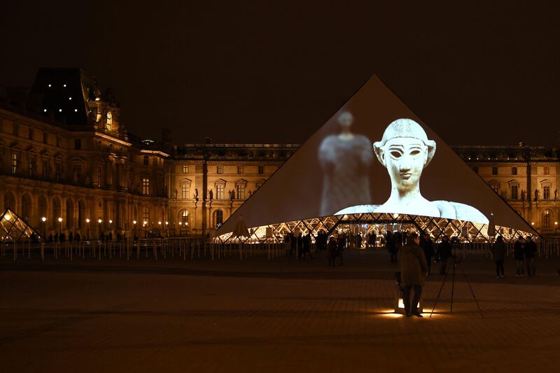 Images of the art displayed in the Louvre Abu Dhabi are projected onto the Louvre Pyramid in Paris Wednesday night to mark the opening of the museum on Saadiyat island. Eric Feferberg / AFP