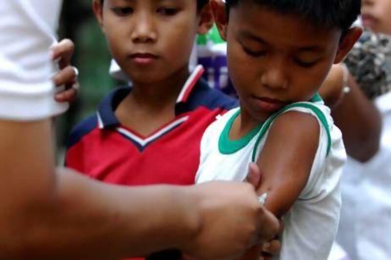 A Filipino nurse giving a boy his measles vaccine in a slum area in Tondo, Manila, on February 23, 2010. Medecins Sans Frontieres has warned at the first Global Vaccines Summit that children in developing countries will suffer if vaccine prices continue to go up. Noel Celes / AFP Photo