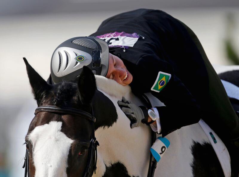 Yane Marques, of Brazil, pats her horse Over The Odds after completing the course in the equestrian show jumping stage of the women's modern pentathlon at the 2012 Summer Olympics, Sunday, Aug. 12, 2012, in London. (AP Photo/David Goldman) *** Local Caption ***  APTOPIX London Olympics Modern Pentathlon Women.JPEG-07e1f.jpg
