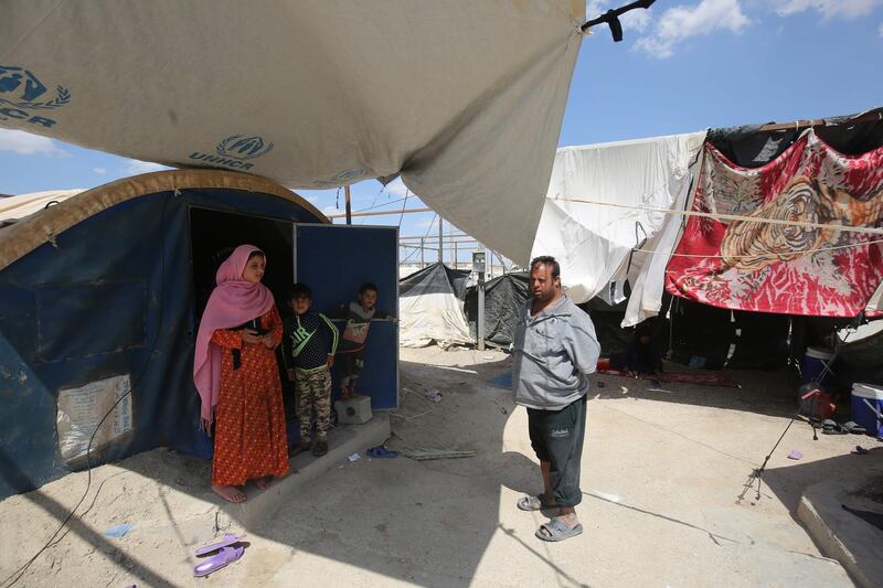 Displaced Iraqis stand outside a tent where they are taking shelter in a camp for internally displaced people near al-Khalidiyeh in Iraq's western Anbar province. While the election campaign is in full swing elsewhere in Iraq, the country's displaced camps barely register on the radars of those running for office, despite housing hundreds of thousands of people. Ahmad Al Rubaye / AFP