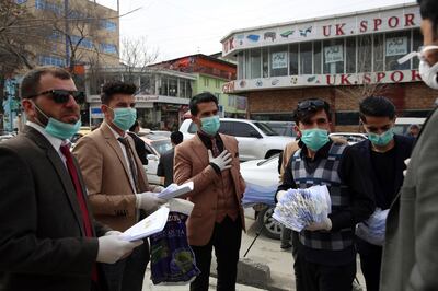 Civil society activists wearing face masks distribute written information to passers-by during a campaign to raise awareness of the new coronavirus in Kabul, Afghanistan, Monday, March 16, 2020. For most people, the new coronavirus causes only mild or moderate symptoms. For some it can cause more severe illness. (AP Photo/Rahmat Gul)