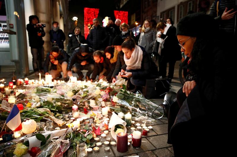 People cry as they light candles in tribute to the victims of the deadly shooting in Strasbourg, France. Reuters