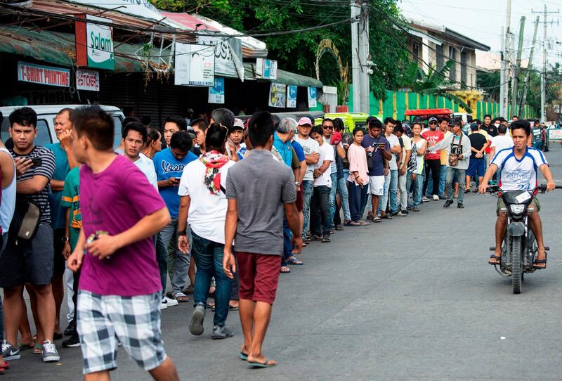 People line up to cast their ballot at a voting precinct in Cotabato on the southern Philippine island of Mindanao on January 21, 2019, during a vote on giving the nation's Muslim minority greater control over the region. A decades-long push to halt the violence that has claimed some 150,000 lives in the southern Philippines culminated on January 21 with a vote on giving the nation's Muslim minority greater control over the region. / AFP / Noel CELIS
