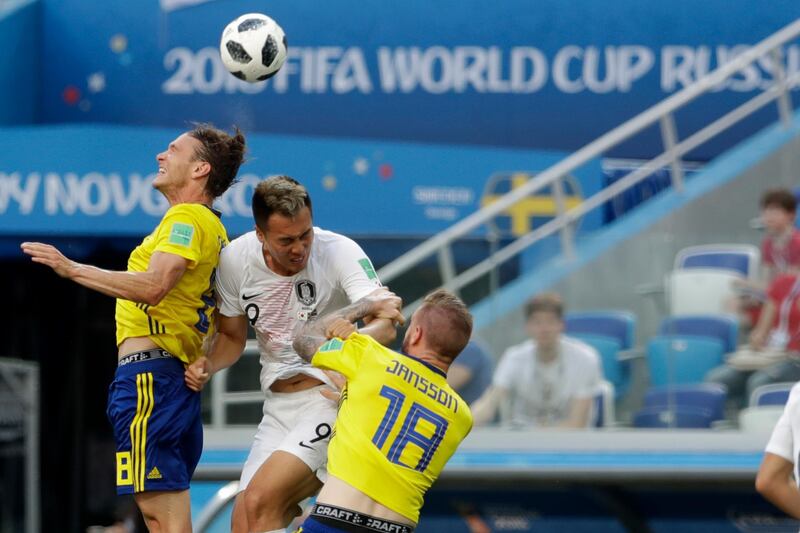 South Korea's Kim Shin-wook, centre, jumps for the ball against Sweden's Albin Ekdal, left, and Pontus Jansson. David Josek / AP Photo