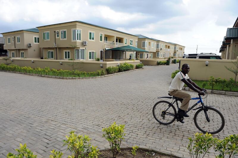 A cyclist rides past dozens of detached three-bedroom apartments at Haggai Estate, Redeption Camp on Lagos Ibadan highway in Ogun State, southwest Nigeria on August, 30, 2012. The high cost of living and the massive urbanization of Lagos, the largest city and the economic capital of Nigeria, has engineered a migration of residents mostly middle class and the poor to neighbouring towns in Ogun State, both in southwest part of the country in search of cheap accommodations. Estate developers are quick in exploiting the high cost and scarcity of accommodation leading to emerging new towns, modern estates to accommodate the spillover in Lagos. AFP PHOTO/PIUS UTOMI EKPEI (Photo by PIUS UTOMI EKPEI / AFP)