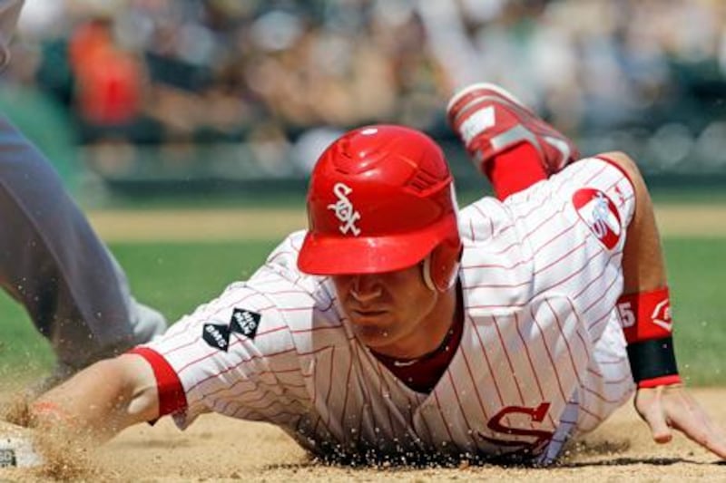 Chicago White Sox's Gordon Beckham safely dives back to first base against the Milwaukee Brewers during the sixth inning of an interleague baseball game in Chicago, Sunday, June 24, 2012. The White Sox won 1-0. (AP Photo/Nam Y. Huh)