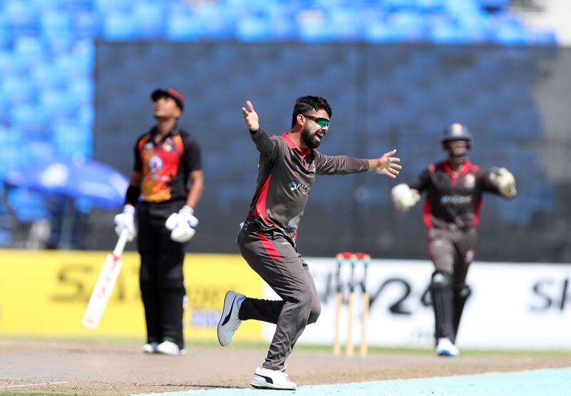 The UAE's Basil Hameed takes the wicket of PNG's Charles Amini at the Sharjah Cricket Stadium.