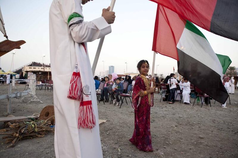A young girl proudly hoists the UAE flag in Sharjah. Antonie Robertson/The National