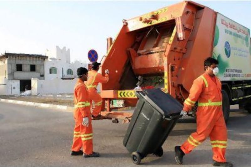 Boys from West Coast Akmercan Cleaning Services collect waste from recycle bin from the villas in Khalifa City B area in Abu Dhabi. Ravindranath K / The National