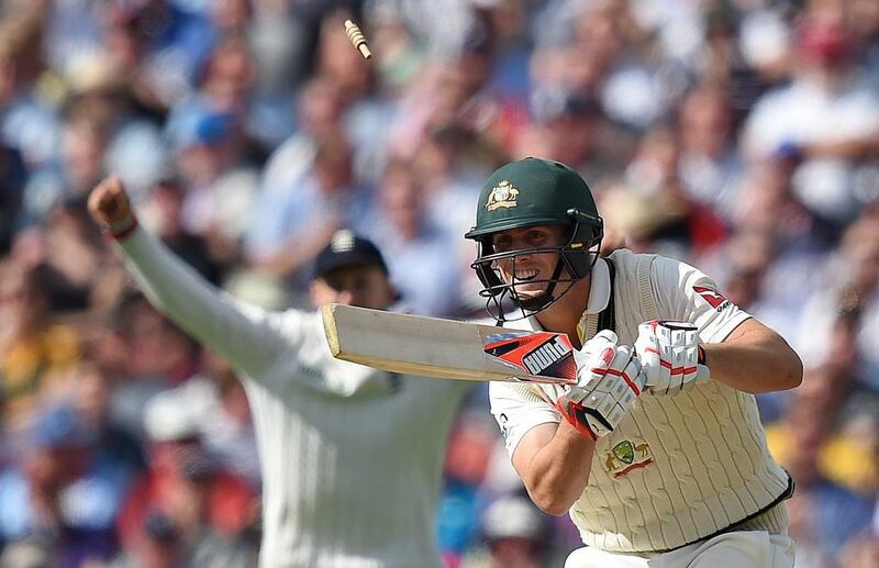 Bails fly over the head of Mitchell Marsh after getting bowled out by Steven Finn. Paul Ellis / AFP