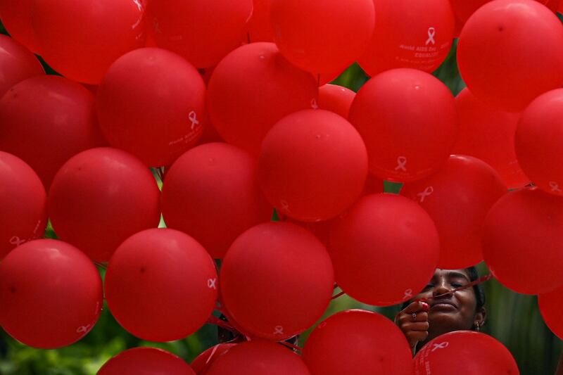 A student holds balloons as she takes part in an awareness campaign on World Aids Day in Chennai. AFP

