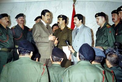 Picture released by Iraq's official news agency INA 07 January 2003 shows President Saddam Hussein (3rd L) speaking to senior officers at the Republican Guards headquarters in Baghdad, in the presence of their chief, his son Qusay (grey suit/4th R). UN arms experts hunting for Iraq's alleged weapons of mass destruction used helicopters today for the first time since launching inspections last November 27 after a four-year break.  AFP PHOTO/INA/HO (Photo by INA / AFP)
