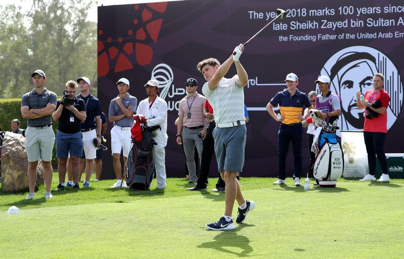 Niall Horan plays a shot watched by Rory McIlroy at Emirates Golf Club. David Cannon / Getty Images