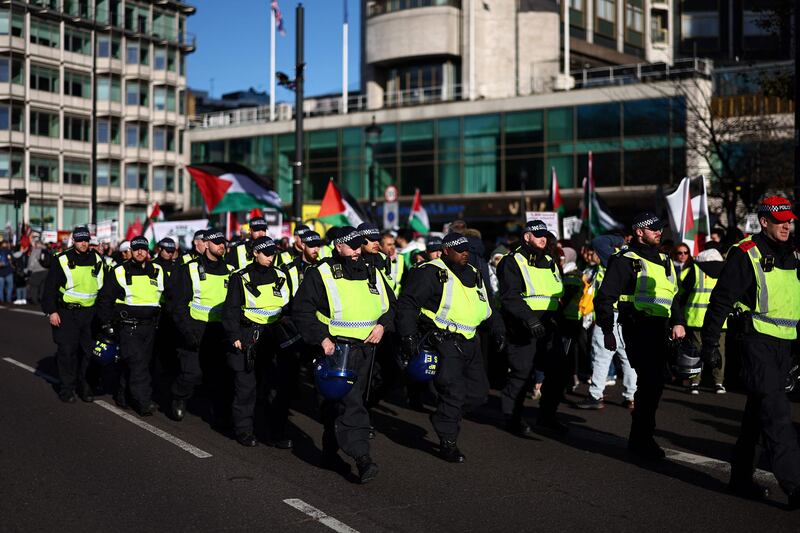 Police officers keep an eye on protesters during a 'National March For Palestine'. AFP