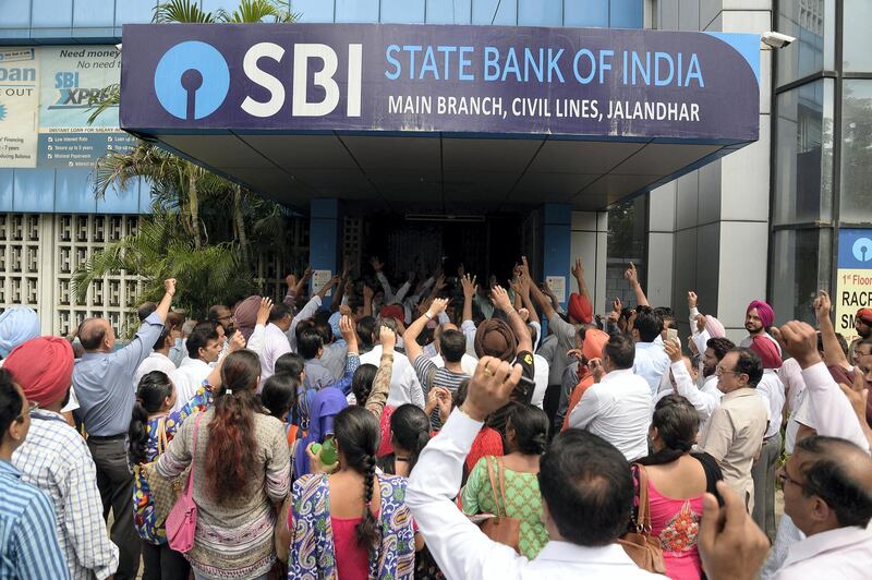 Striking Indian bank employees take part in a protest outside a branch of the State Bank of India (SBI) in Jalandhar on August 22, 2017.
Bank employee unions have called for a nationwide strike in India to protest against privatisation and merger of public sector banks. / AFP PHOTO / SHAMMI MEHRA