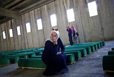 FILE PHOTO: A woman cries near coffins containing the bodies of newly identified victims of the 1995 Srebrenica massacre at the Memorial Center in Potocari, near Srebrenica, Bosnia and Herzegovina July 10, 2015. Bosnia will mark the 25th anniversary of the massacre of more than 8,000 Bosnian Muslim men and boys on July 11, 2020, with many relatives unable to attend due to the novel coronavirus pandemic.  REUTERS/Stoyan Nenov/File Photo