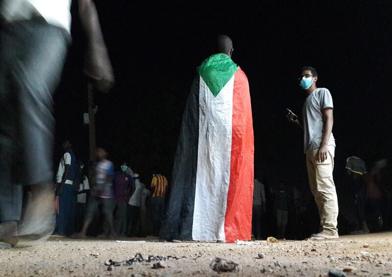 TOPSHOT - A Sudanese demonstrator wears a national flag during an anti-government protest in the Haj Yousef neighbourhood of the Bahari district in the capital Khartoum on January 22, 2019. Sudanese police fired tear gas at hundreds of protesters in the capital and its twin city of Omdurman today as demonstrators staged night-time rallies against the government.
The after-dark demonstrations were the latest in more than a month of escalating protests against President Omar al-Bashir's three-decade rule.
 / AFP / STRINGER
