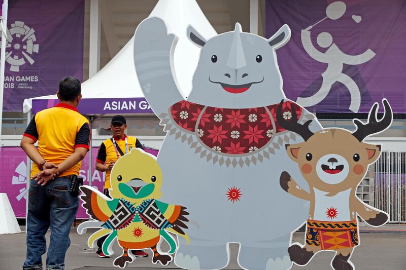 Volunteers wait outside a venue as final preparations are made at the 18th Asian Games in Jakarta, Indonesia, Friday, Aug. 17, 2018. The Games which officially opens on Saturday Aug. 18, will feature approximately 11,500 athletes, which is about 1,000 more than a typical Summer Olympics. (AP Photo/Firdia Lisnawati)