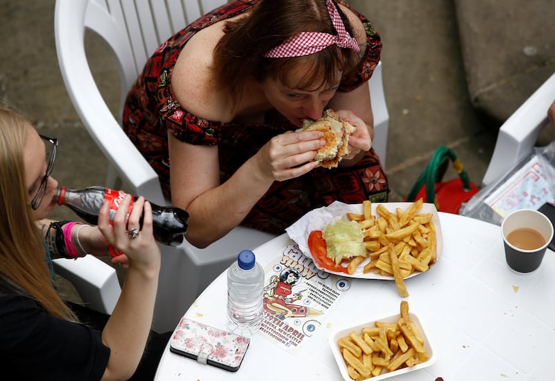Visitors to the London Tattoo Convention eat fast-food available at the event, in London Britain, September 23, 2017. REUTERS/Peter Nicholls