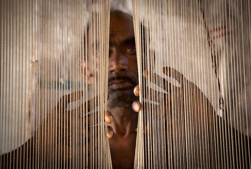 'Threads' by Lisa Kristine. Speaking about the subject of the photograph, she says: "He is more than 50 years old and is enslaved weaving carpets to pay off a modest loan he took 12 years ago. He doesn’t know if he’ll ever be free to work for someone else."