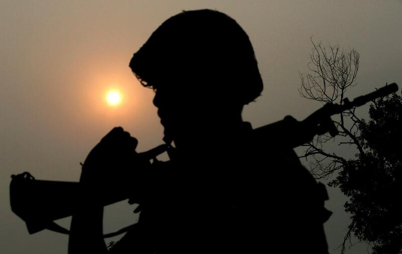 A Border Security Force (BSF) soldier is silhouetted against the sun as he patrols near the fence at the India-Pakistan International Border at outpost Chenab of Dewali post of Akhnoor sector.  Jaipal Singh / EPA