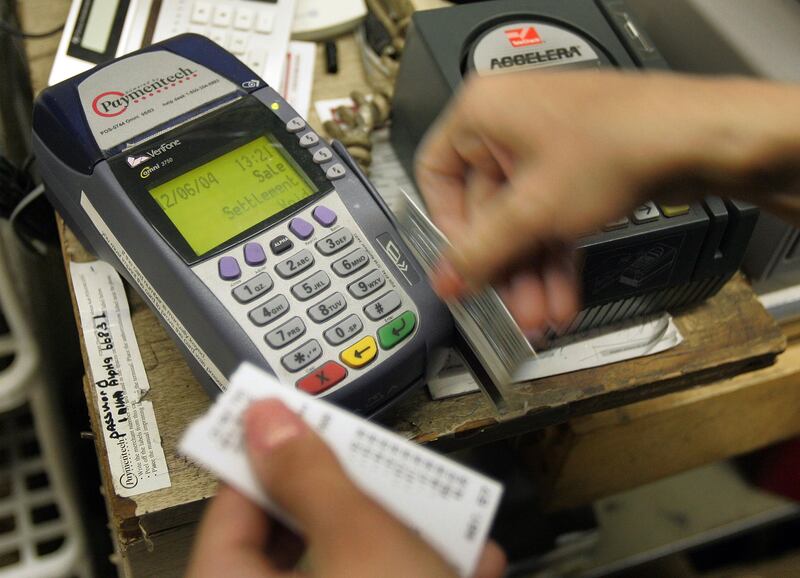 CHICAGO - DECEMBER 6:  A sales associate works on a customer's transaction with a credit card at Cut Rate Toys December 6, 2004 in Chicago. Personal debt is reaching record highs and personal savings is reaching all time lows, yet consumer spending accounts for two-thirds of the $11 trillion US economy.  (Photo by Tim Boyle/Getty Images)