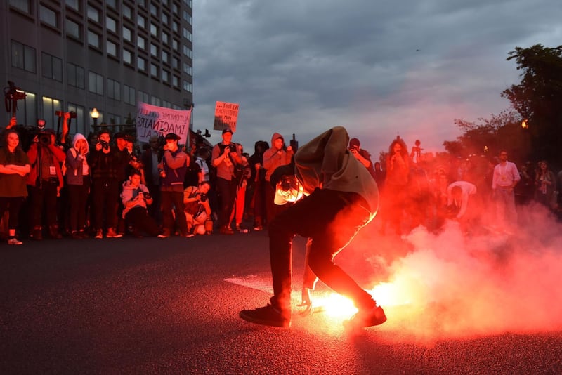 A protester picks up a flare during an anti-G7 demonstrations in Quebec City, Canada. Martin Ouellet-Diotte / AFP Photo