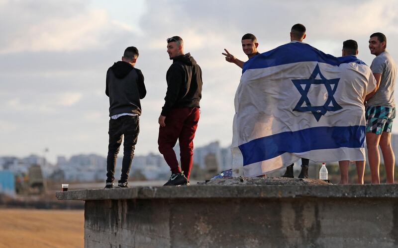 Israelis gather to watch the Iron Dome aerial defence system launch a missile to intercept a rocket launched from the Gaza Strip, above the city of Ashdod. AFP